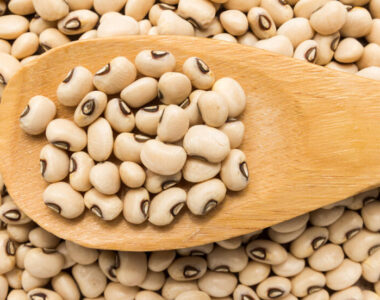 Vigna unguiculata is scientific name of Black Eyed Pea legume. Also known as Goat Pea, California Blackeye and Feijao Fradinho. Grains in wooden spoon. Close up.